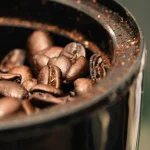 Imagem de borda do reservatório de um moedor com grãos de café