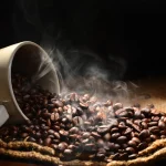 Imagem xícara com grãos de café quente derramando sobre tecido de saco